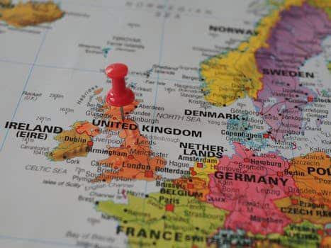 Close-up of a European map highlighting the UK with a red pin, perfect for geography themes.